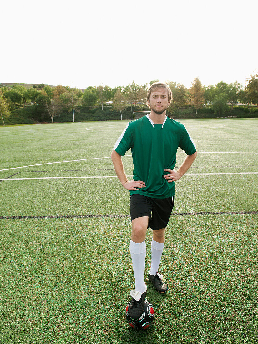 Caucasian soccer player standing on soccer field with ball, Ladera Ranch, California, USA