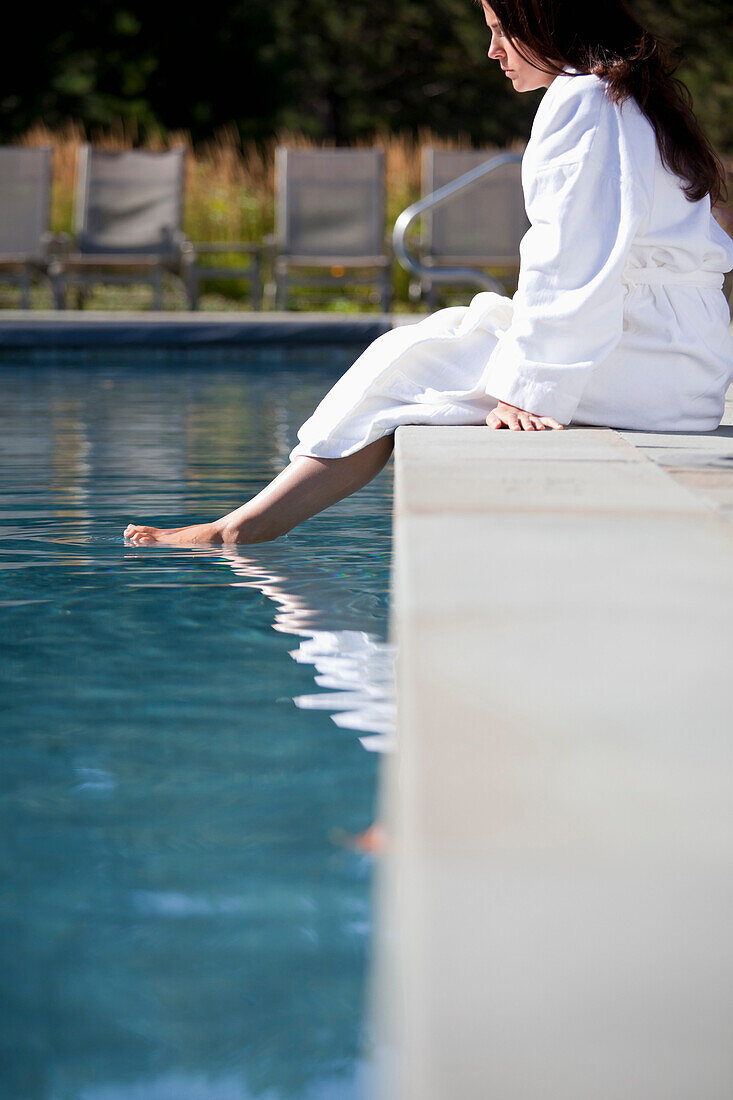 Woman soaking feet in swimming pool, Stowe, Vermont, USA