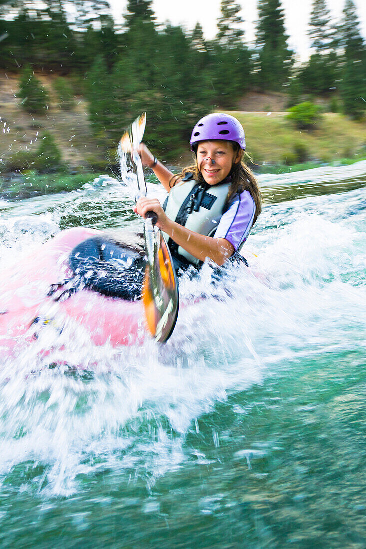 Caucasian teenager kayaking in river, Boise, Idaho, USA