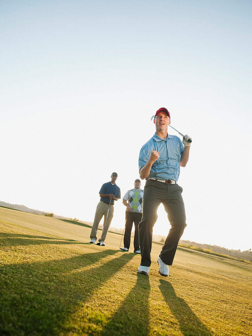 Friends watching golfer cheering, Mission Viejo, California, USA