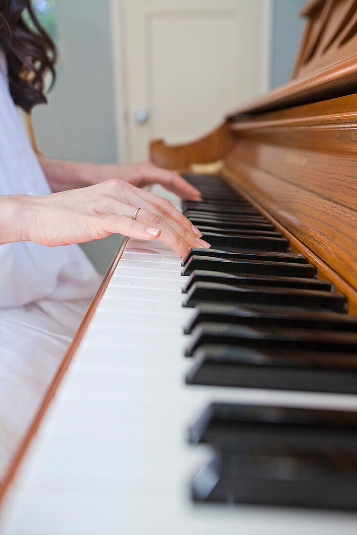 Close up of mixed race woman playing piano, Los Angeles, California, United States
