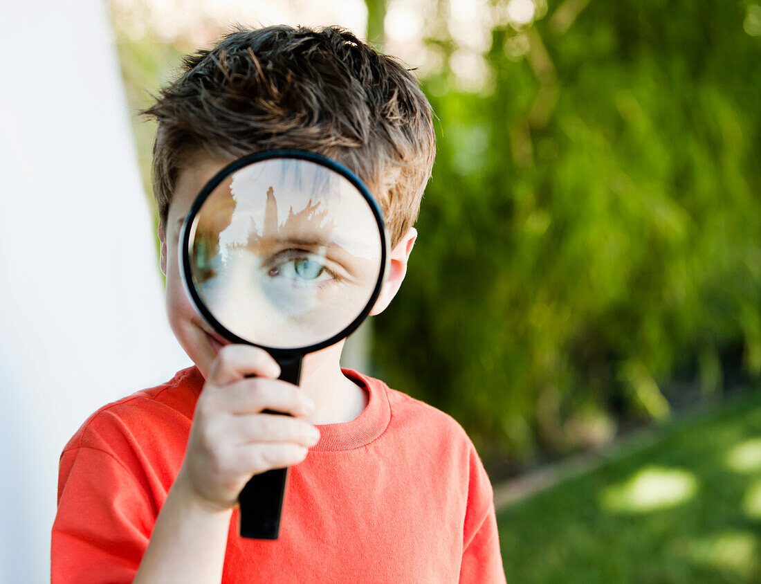 Caucasian boy looking through magnifying glass, Los Angeles, California, USA