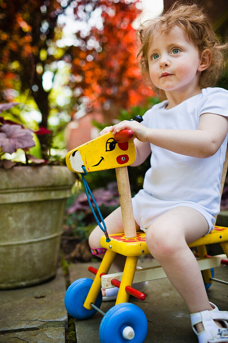 Girl riding wooden giraffe, Washington, DC, USA