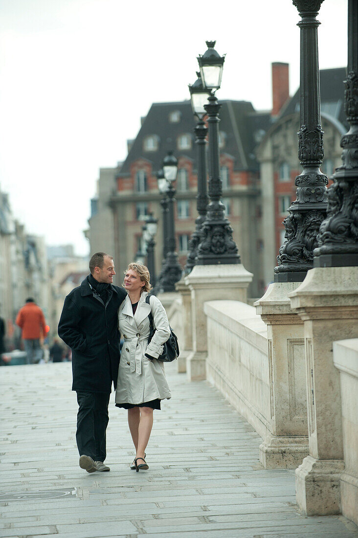 Caucasian couple walking on bridge, Paris, Paris, France