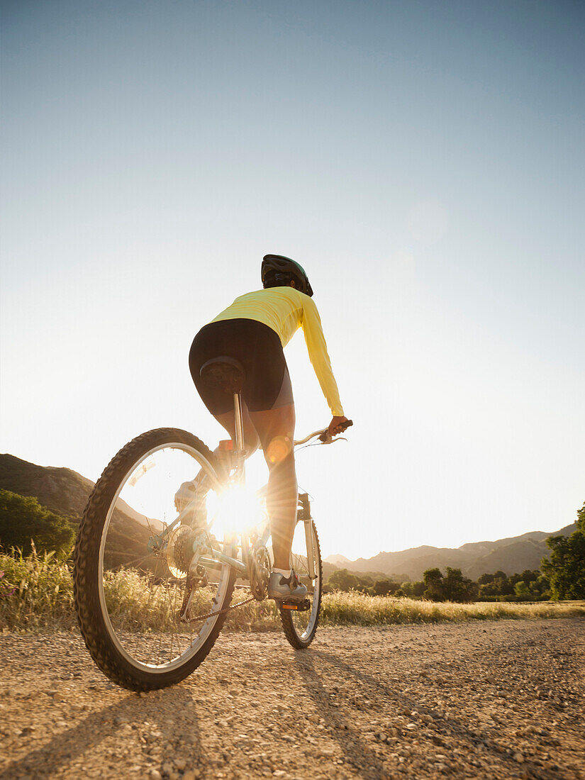 Mixed race woman riding on mountain bike, Calabasas, California, United States