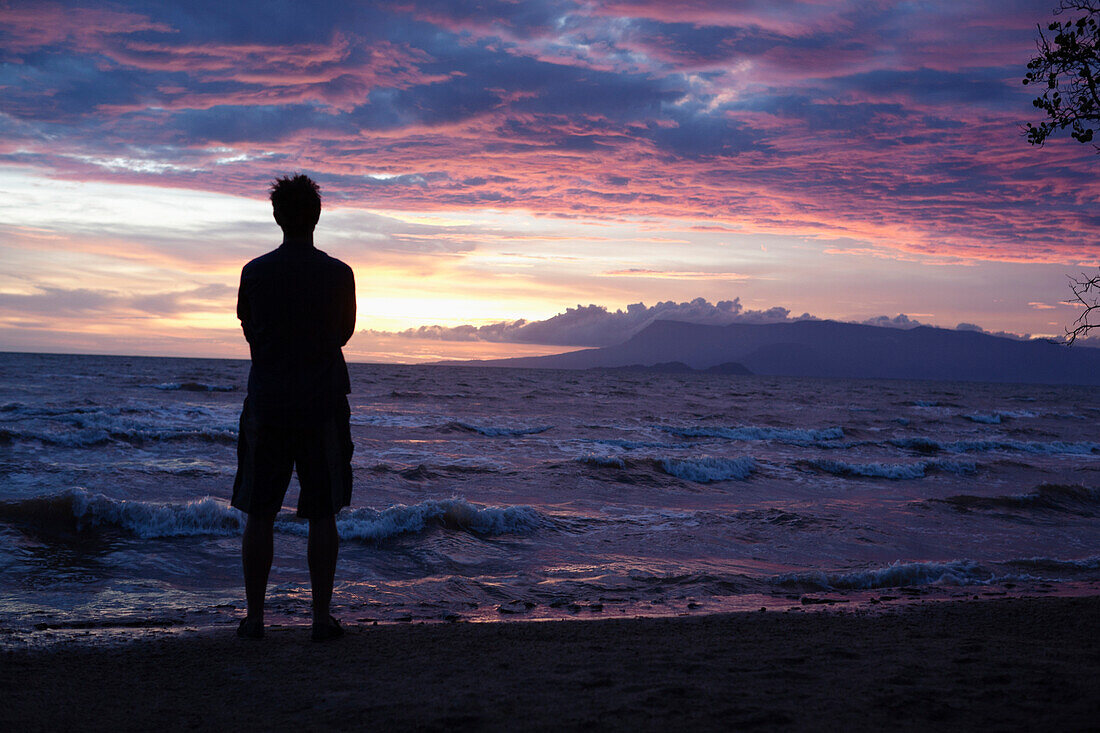 Caucasian man standing on beach viewing sunset, Kep, Kep, Cambodia