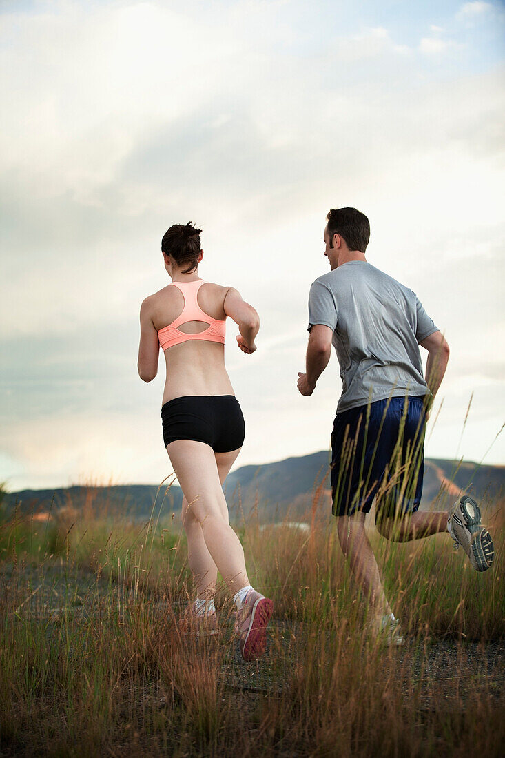 Caucasian couple running together on remote path, South Jordan, Utah, United States