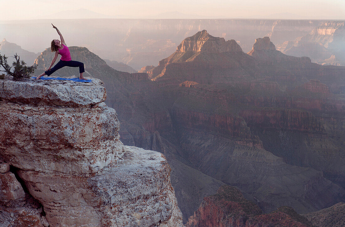Caucasian woman practicing yoga on cliff near canyon, Grand Canyon, Arizona, United States