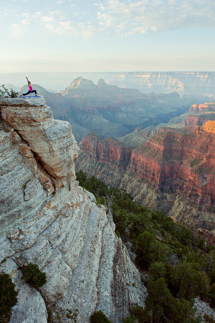 Caucasian woman practicing yoga on cliff near canyon, Grand Canyon, Arizona, United States