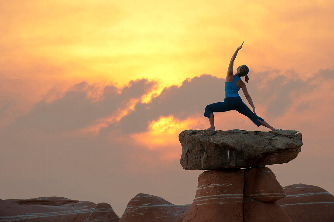 Kaukasische Frau übt Yoga auf einer Felsformation, Kanab, Utah, USA
