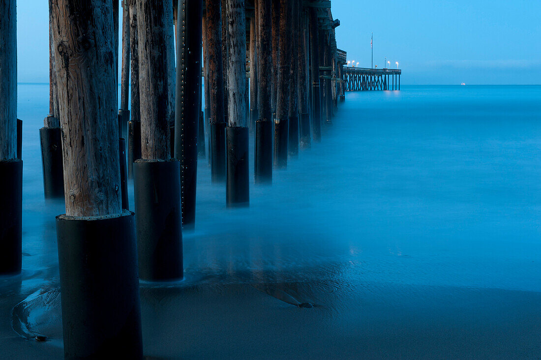 Ocean and dock pilings at beach, Ventura, California, United States