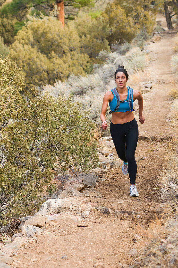 Hispanische Läuferin beim Training in abgelegenem Gebiet, Questa, New Mexico, USA