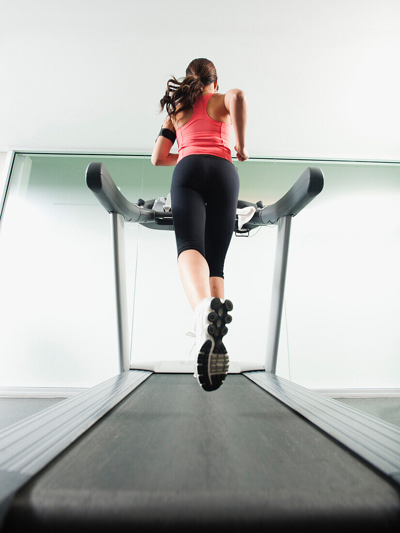 Mixed race woman running on treadmill, Los Angeles, California, USA