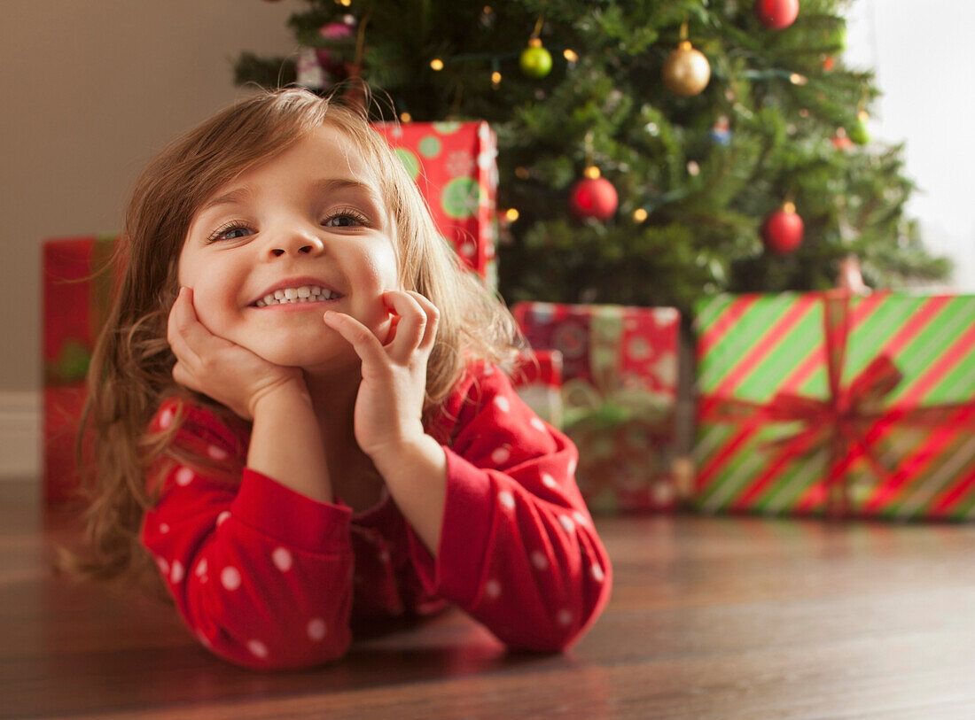 Caucasian girl laying on floor near Christmas tree, Lehi, Utah, USA