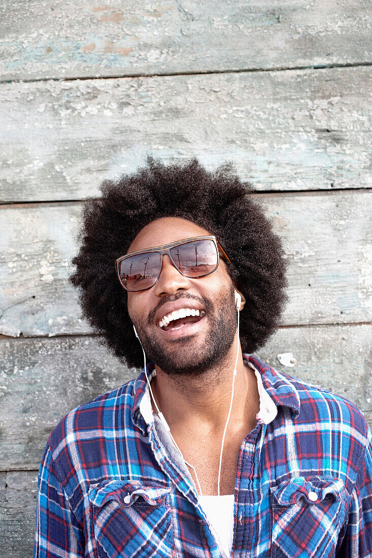 Smiling Black man listening to mp3 player, Los Angeles, California, USA
