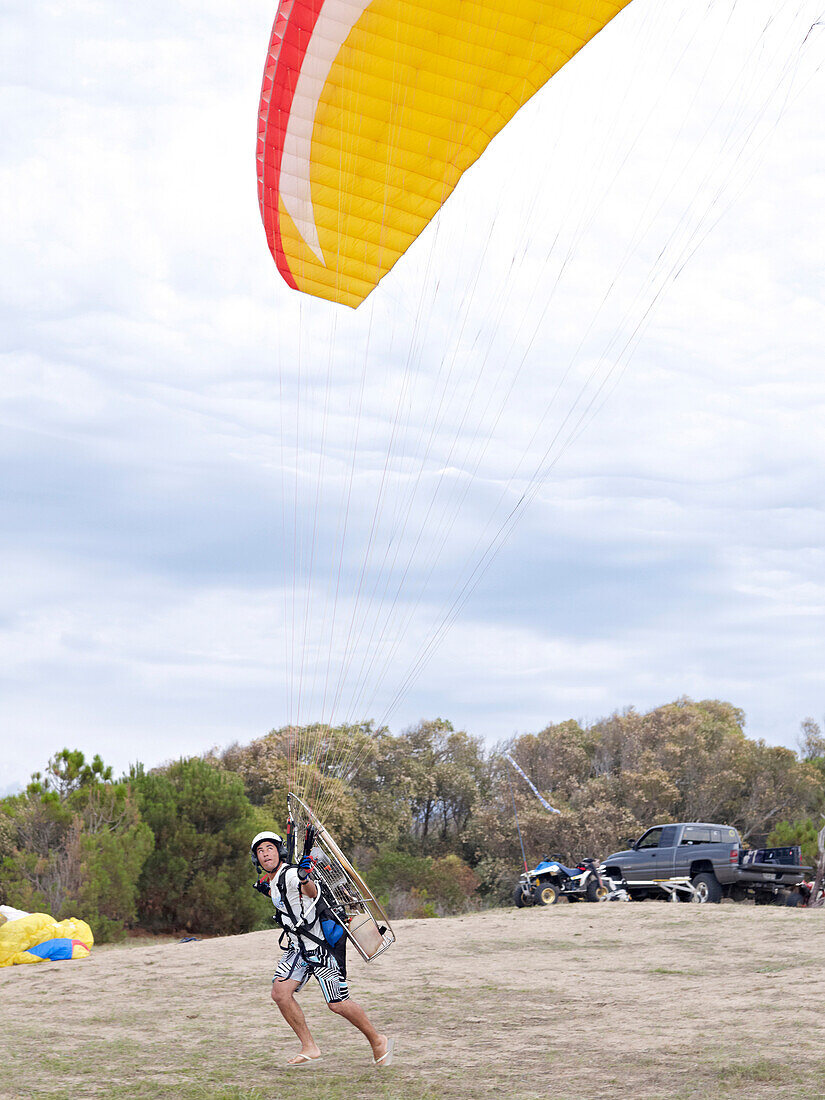 Hispanic man paragliding, Punta del Este, Punta del Este, Uruguay