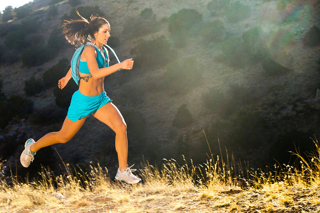 Hispanic woman running in remote area, Albuquerque, New Mexico, USA