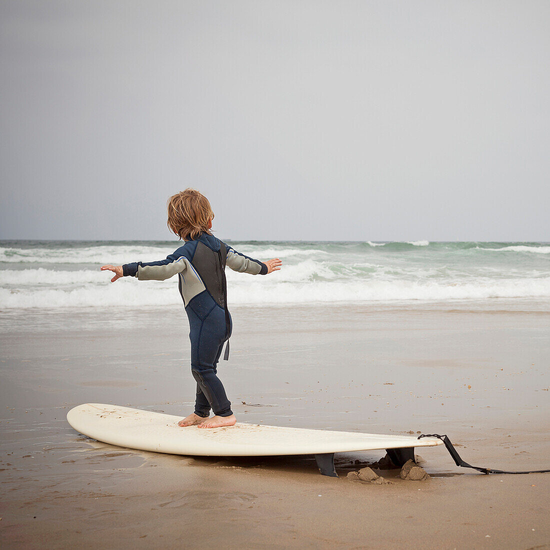 Caucasian boy practicing surfing on beach, Manhattan Beach, California, USA