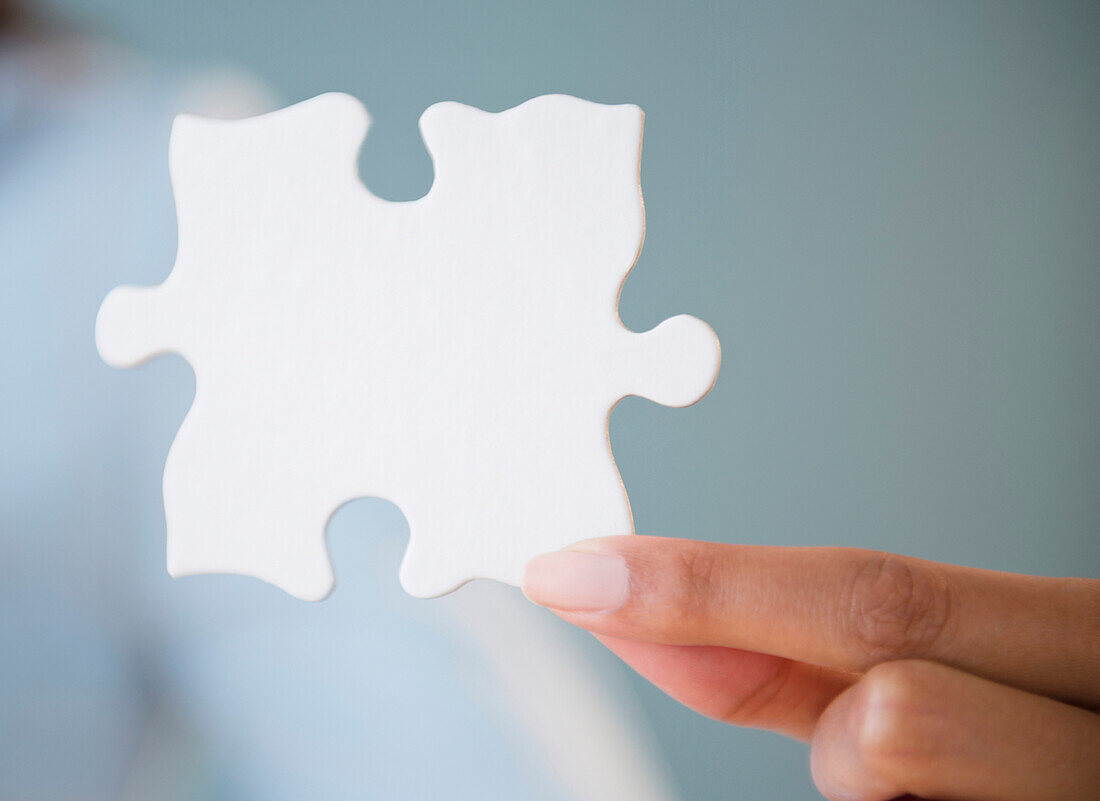 Cape Verdean woman holding puzzle piece, Jersey City, New Jersey, USA