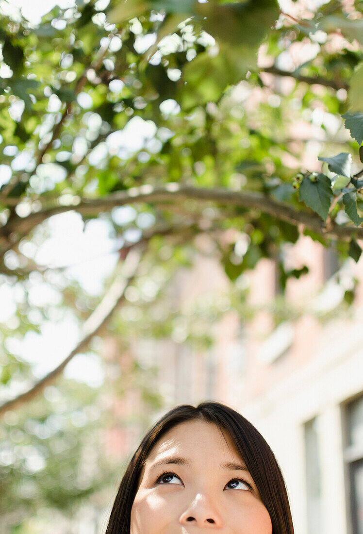 Asian woman looking up, Brooklyn, New York, USA
