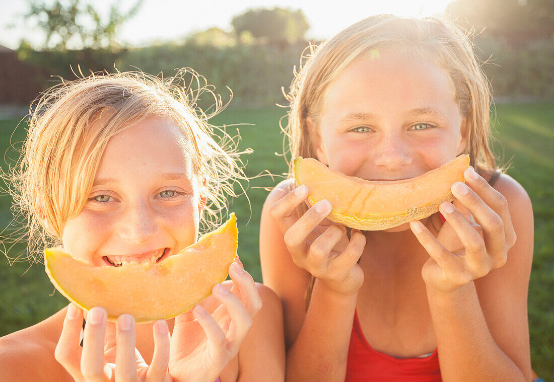 Caucasian girls eating cantaloupe, Lehi, Utah, USA