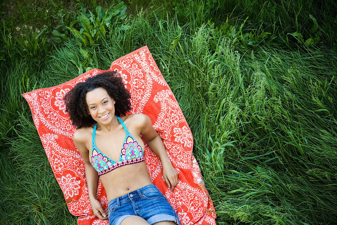 Hispanic woman laying in grass, Hull, Massachusetts, United States