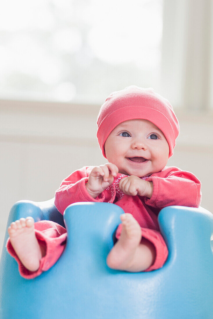Smiling Caucasian baby sitting in chair, Tallahassee, Florida, USA