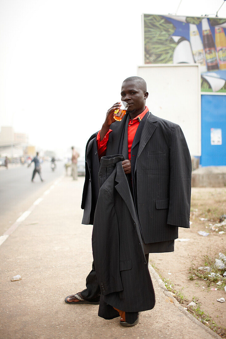 Merchant selling suits at main street, Ganxi, Cotonou, Benin