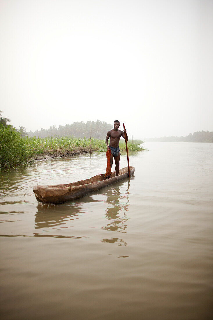 Fischer in einem Einbaum beim Fischen mit einem Wurfnetz auf dem Fluss Mono, Agbanakin, bei Grand-Popo, Mono, Benin