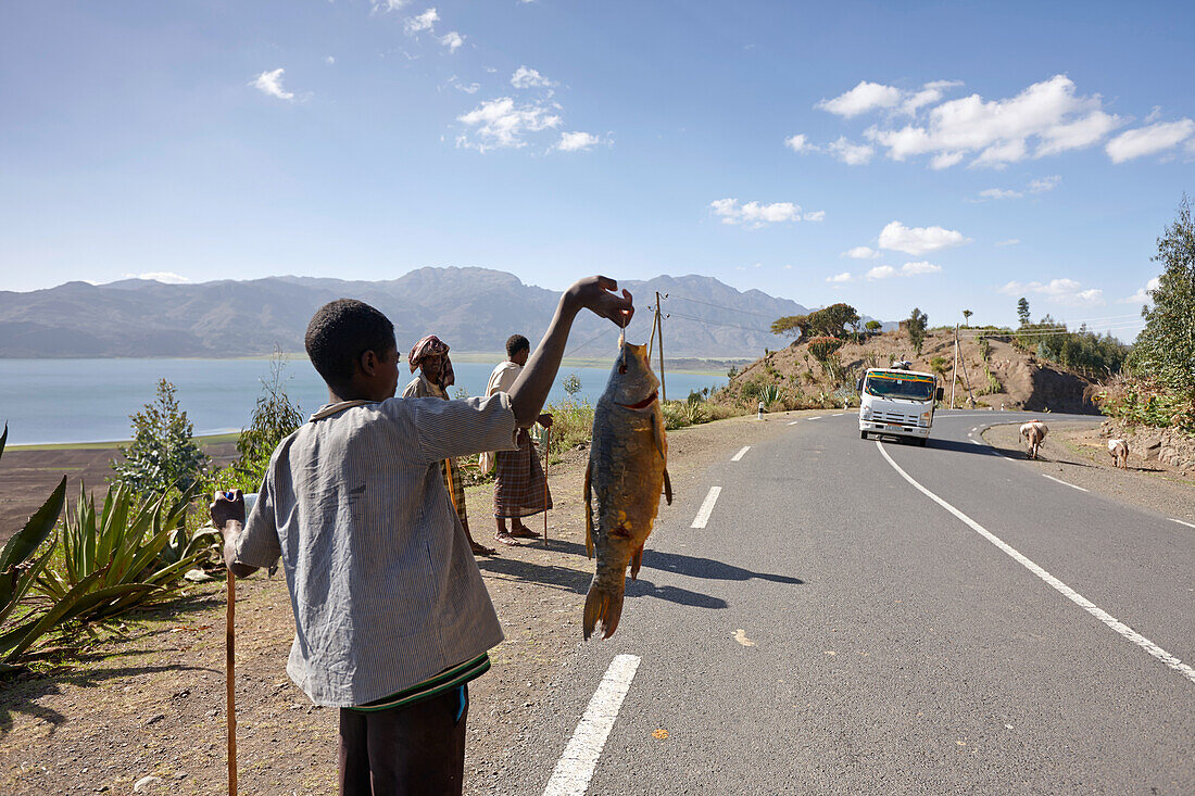 Junge verkauft Fisch am Ufer des Ashange Hayk, bei Maychew, Tigray Region, Äthiopien