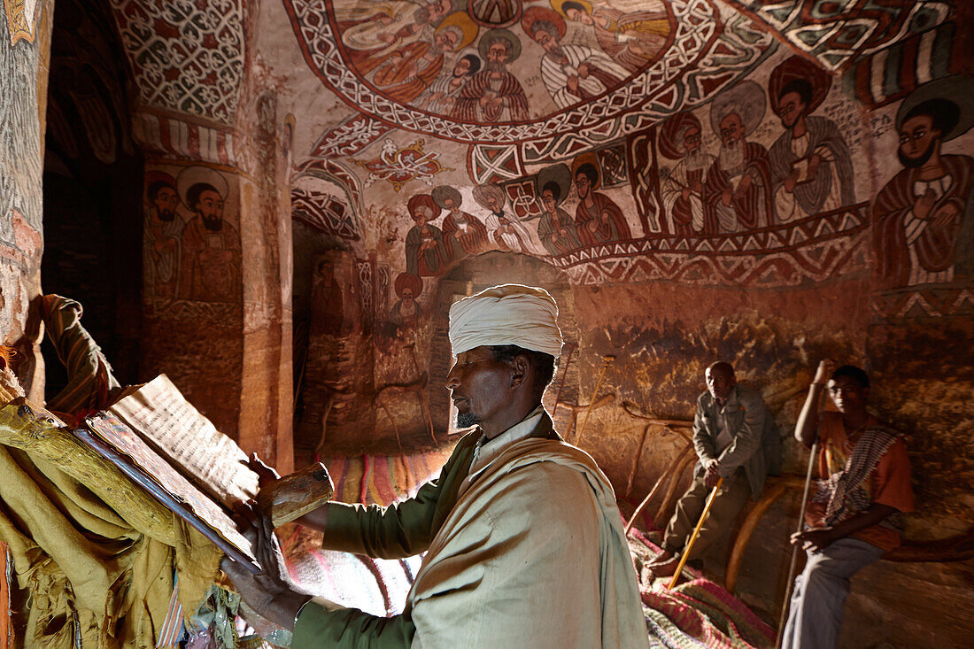 Priester liest in altem religiösem Manuskript aus Ziegenleder, Abuna Yemata Guh Kirche mit Wandmalereien, Hawzien, Tigray Region, Äthiopien