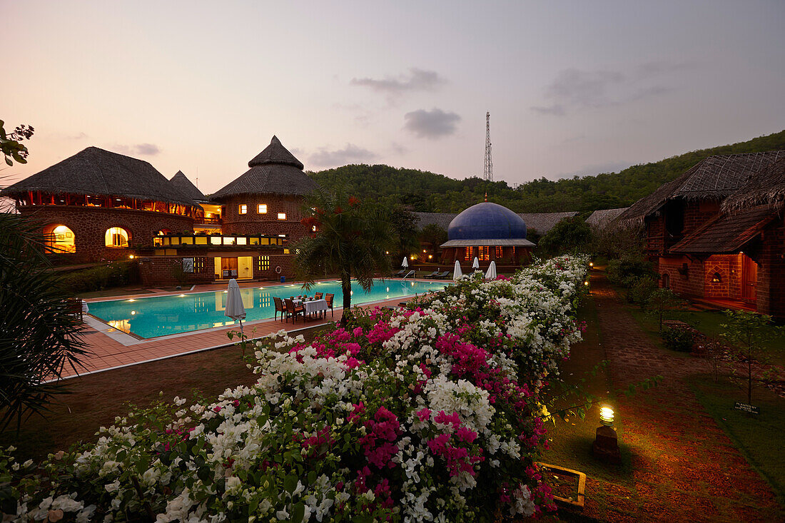 Pool, restaurant and bungalows of a hotel in the evening, Gokarna, Karnataka, India