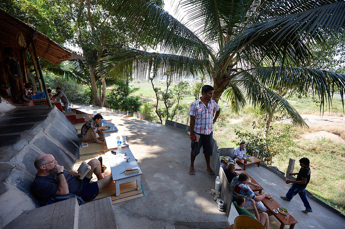 Guests on terrace of a restaurant, Tungabhadra river, Hampi, Karnataka, India