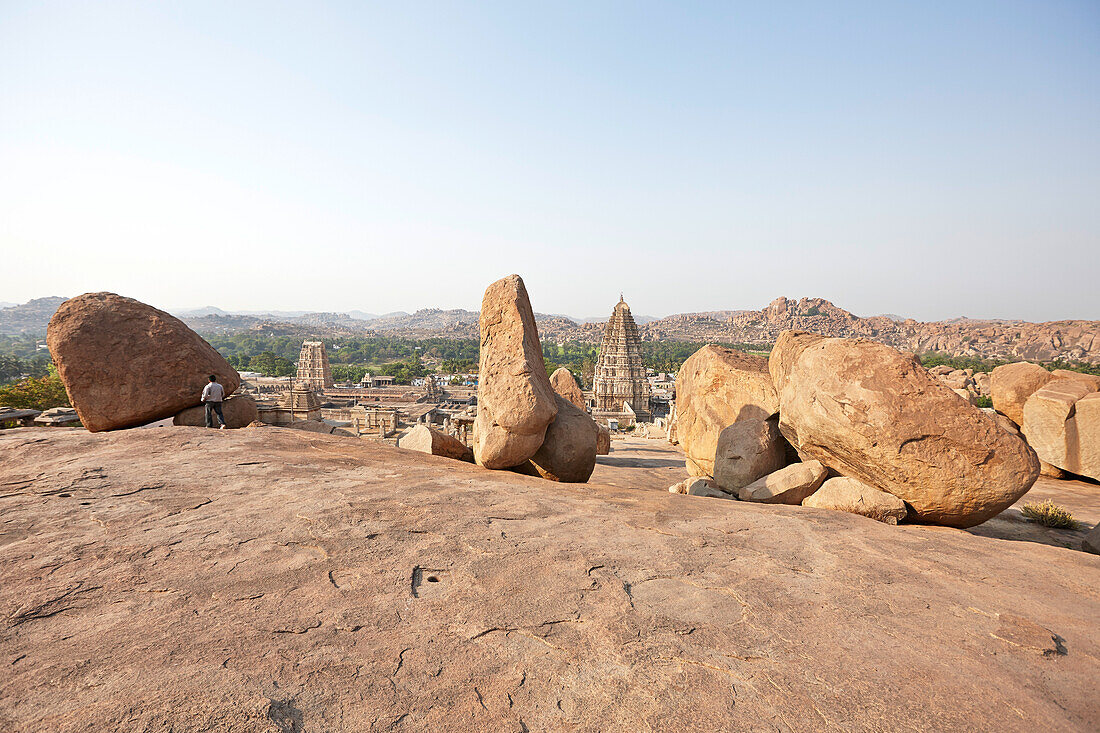 Granitfelsen auf Hemakuta Hill, Virupaksha Tempel im Hintergrund, Hampi, Karnataka, Indien