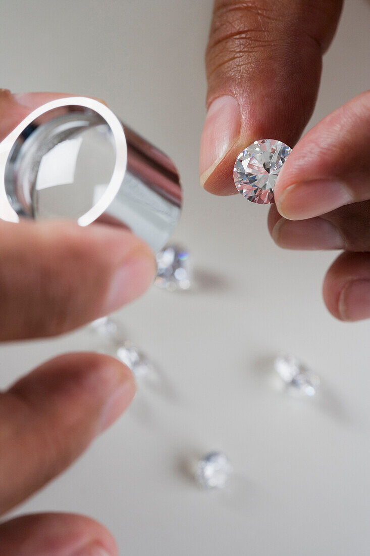 Close up of hands examining diamonds, Unknown