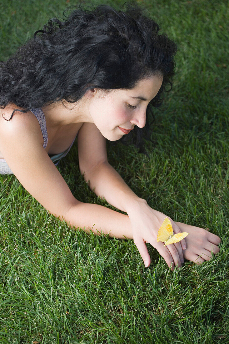 Butterfly resting on young woman's hand, Unknown