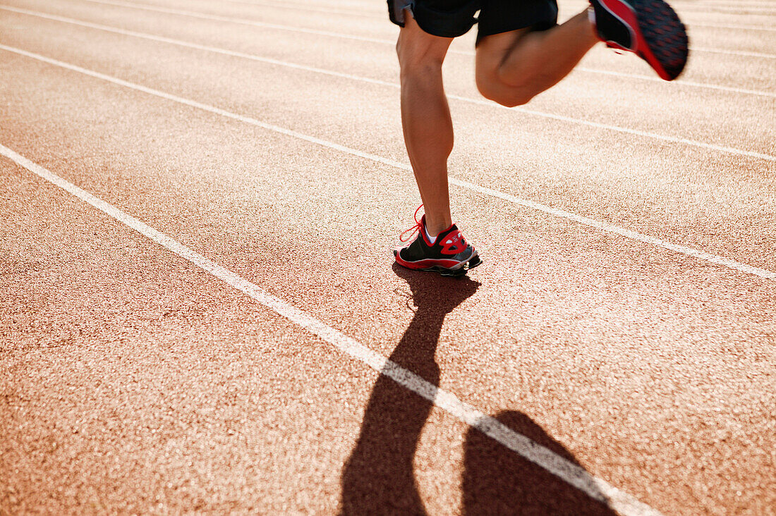 Male athlete running on a track, Seattle, WA