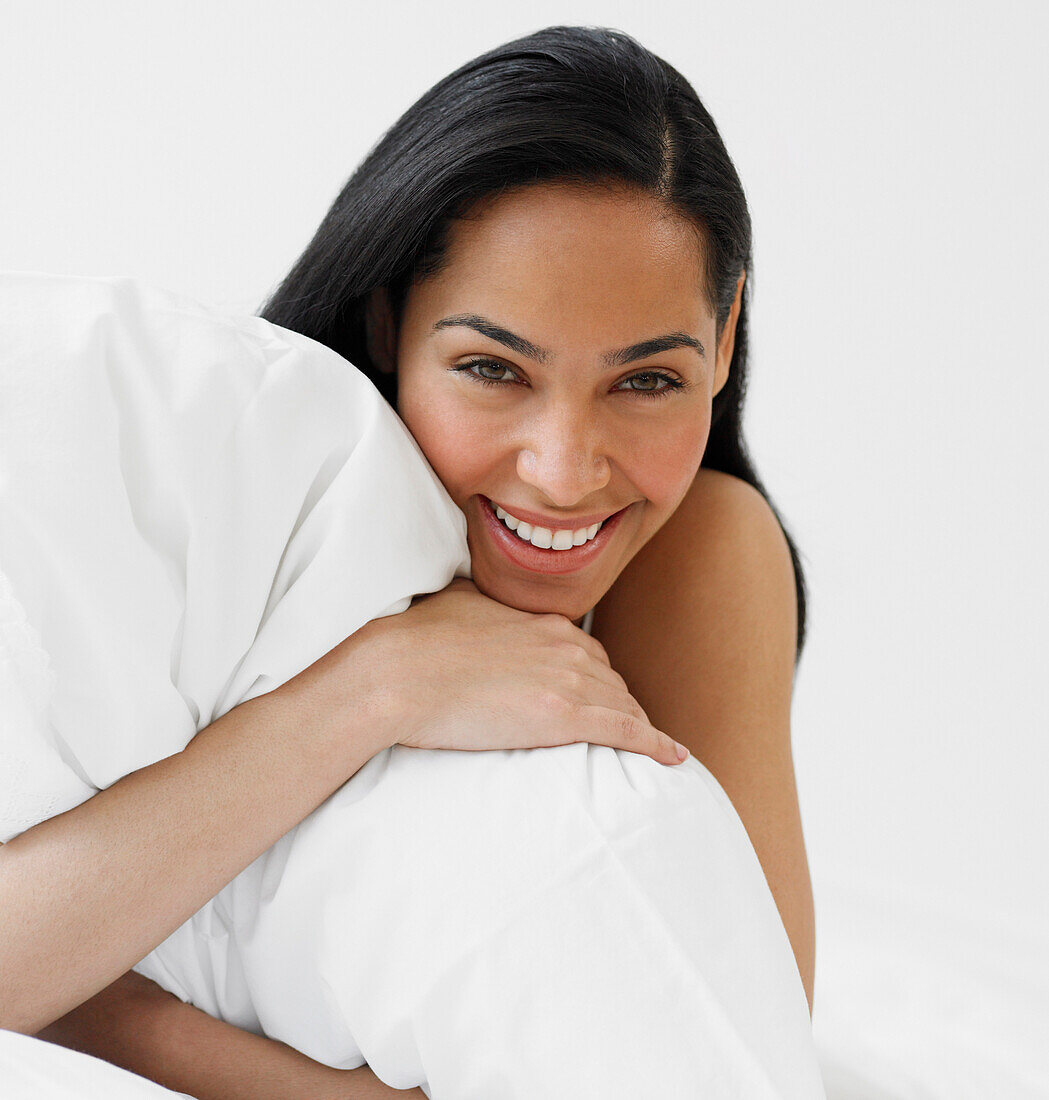 African woman hugging pillow, Unknown