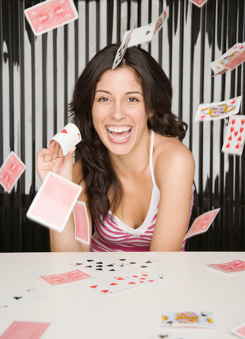 Hispanic woman throwing playing cards, Unknown