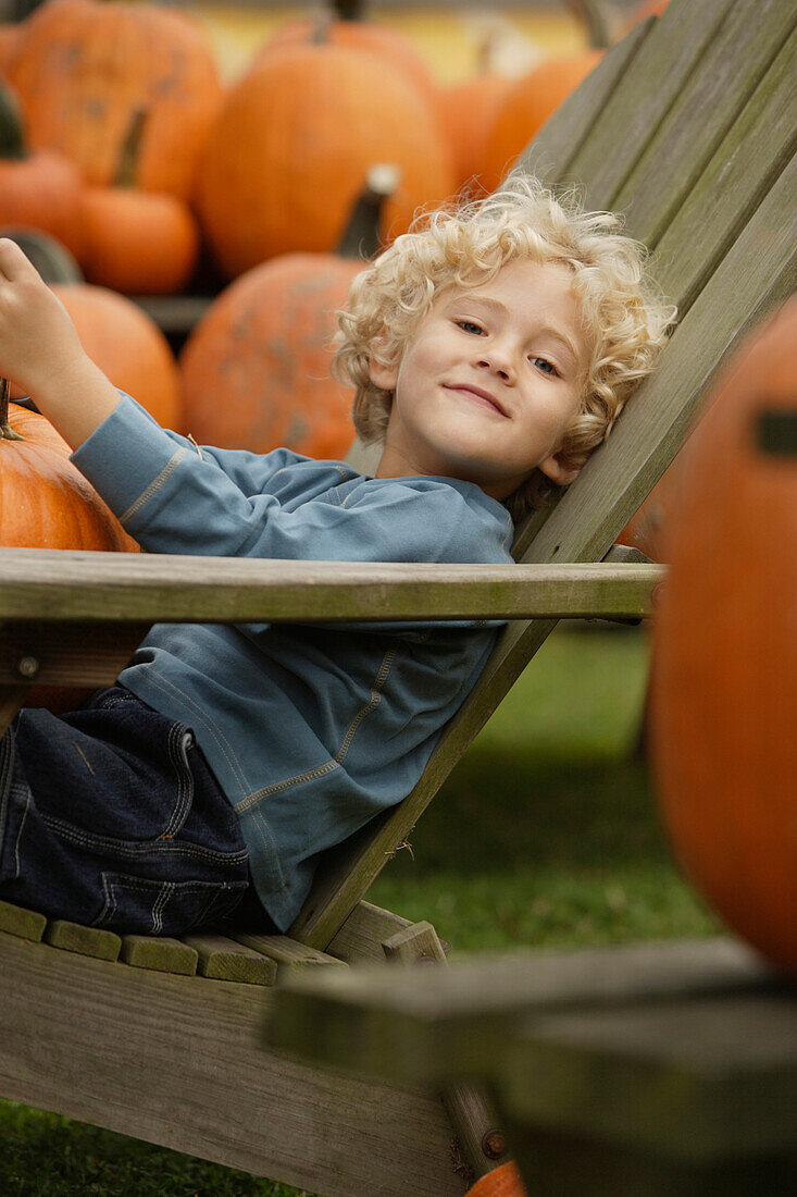 Boy in chair holding pumpkin, Virginia Beach, VA