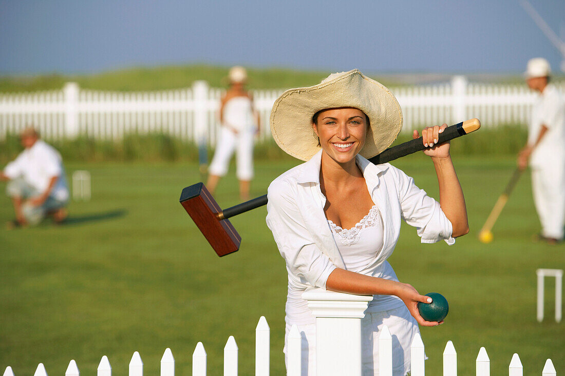 Young woman playing croquet, Cape Cod, MA