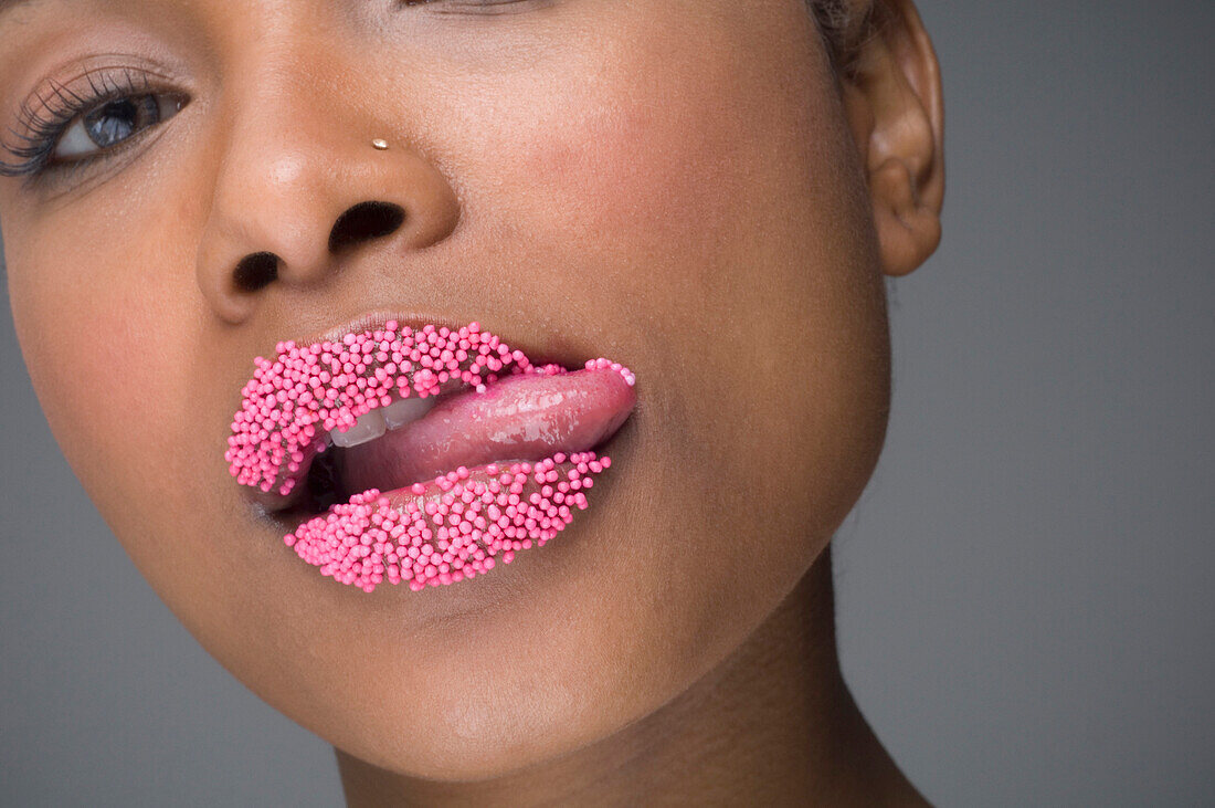 African woman licking sprinkles off lips, Richmond, VA