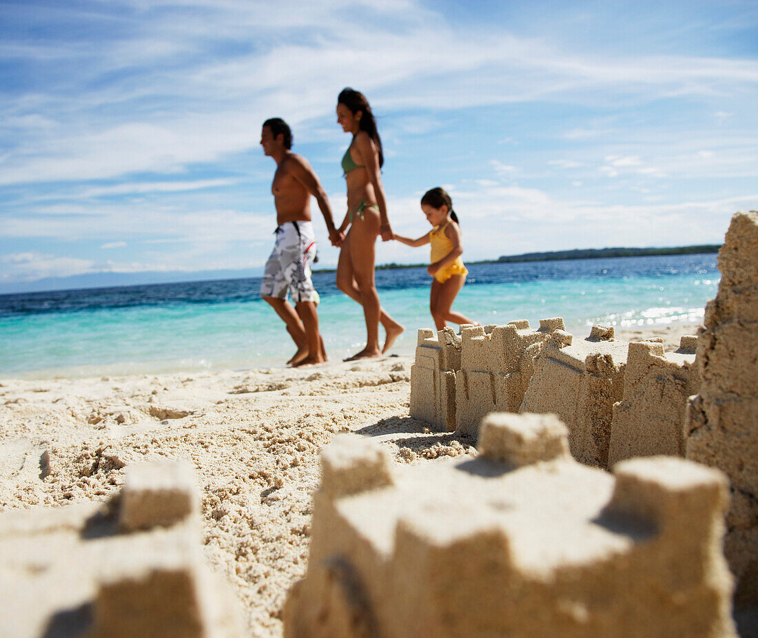 Hispanic family with sand castle in foreground, Morrocoy, Venezuela