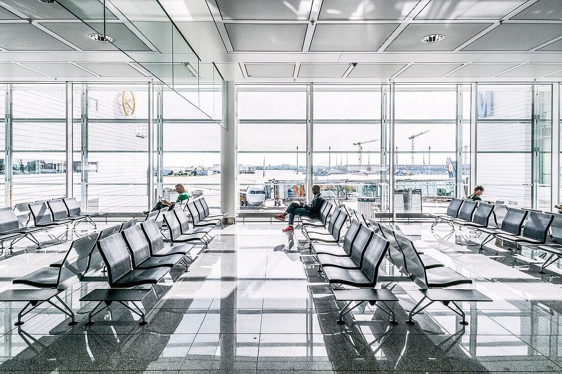 Passengers in waiting area at airport, Germany