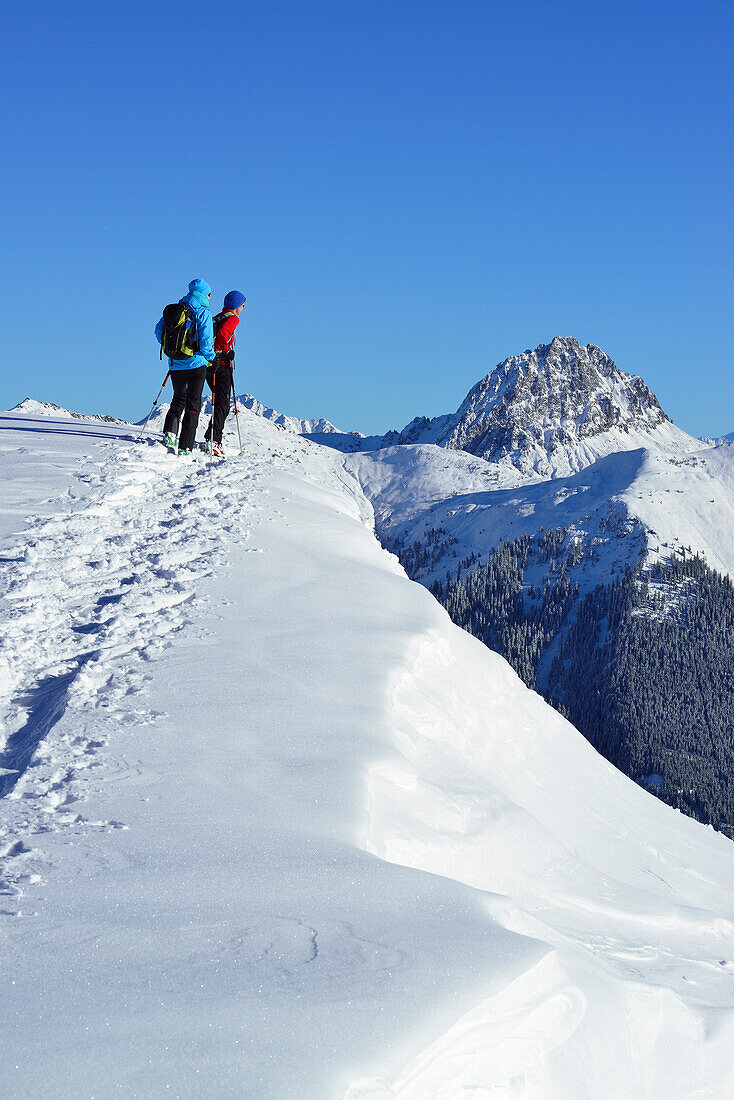 Zwei Skitourgeherinnen steigen zum Steinberg auf, Großer Rettenstein im Hintergrund, Kitzbüheler Alpen, Tirol, Österreich