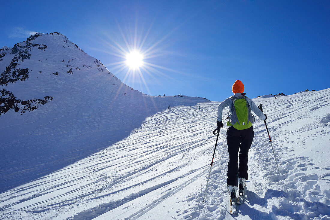 Female back-country skier ascending to Agglsspitze, Pflersch Valley, Stubai Alps, South Tyrol, Italy