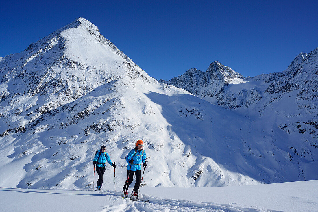 Zwei Frauen auf Skitour steigen zur Kuhscheibe auf, Schrankogel im Hintergrund, Stubaier Alpen, Tirol, Österreich