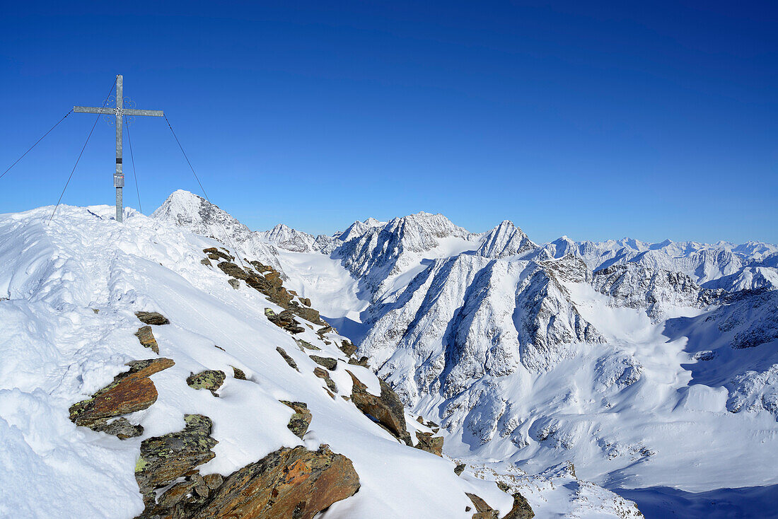Summit cross in snow, Wilde Leck and Oetztal Alps in background, Kuhscheibe, Stubai Alps, Tyrol, Austria