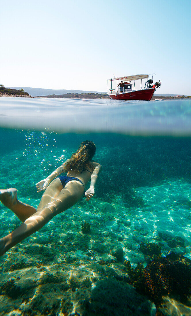 Frau badet in der Blue Lagoon, Diaporos Insel, Vourvourou, Sithonia, Chalkidiki, Griechenland