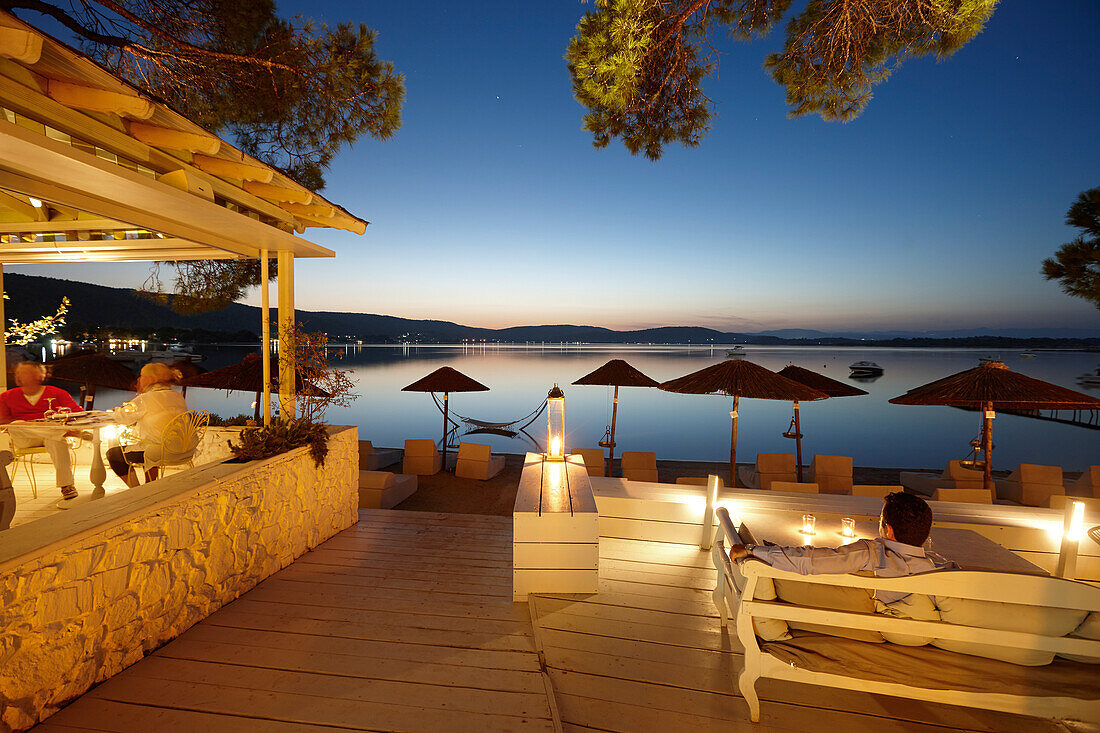 Guests in a beach bar of a hotel in the evening, Vourvourou, Sithonia, Chalkidiki, Greece